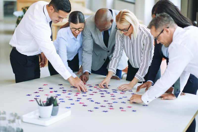 Diverse Group Of Businesspeople Solving A Puzzle I Team Pazle
