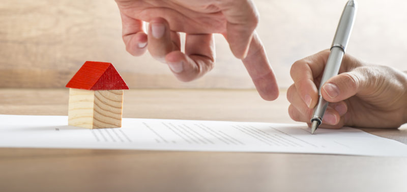 Real Estate Agent Showing His Client Where To Sign A Contract Of